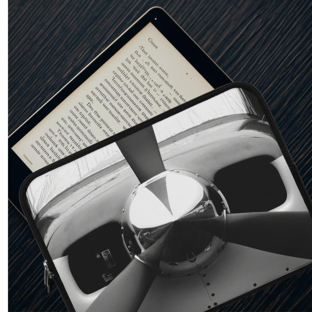 Tablet displaying a black and white image of a car interior on a dark textured surface.