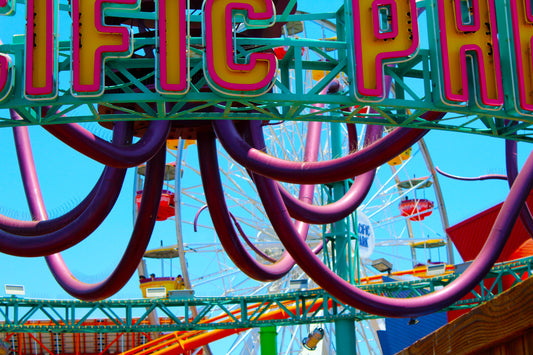 Close-up color photograph of the Santa Monica Pier featuring vibrant amusement park rides and the Pacific Park sign in the background. Ride on the Santa Monica Pier Original Photograph by Kim A. Bailey