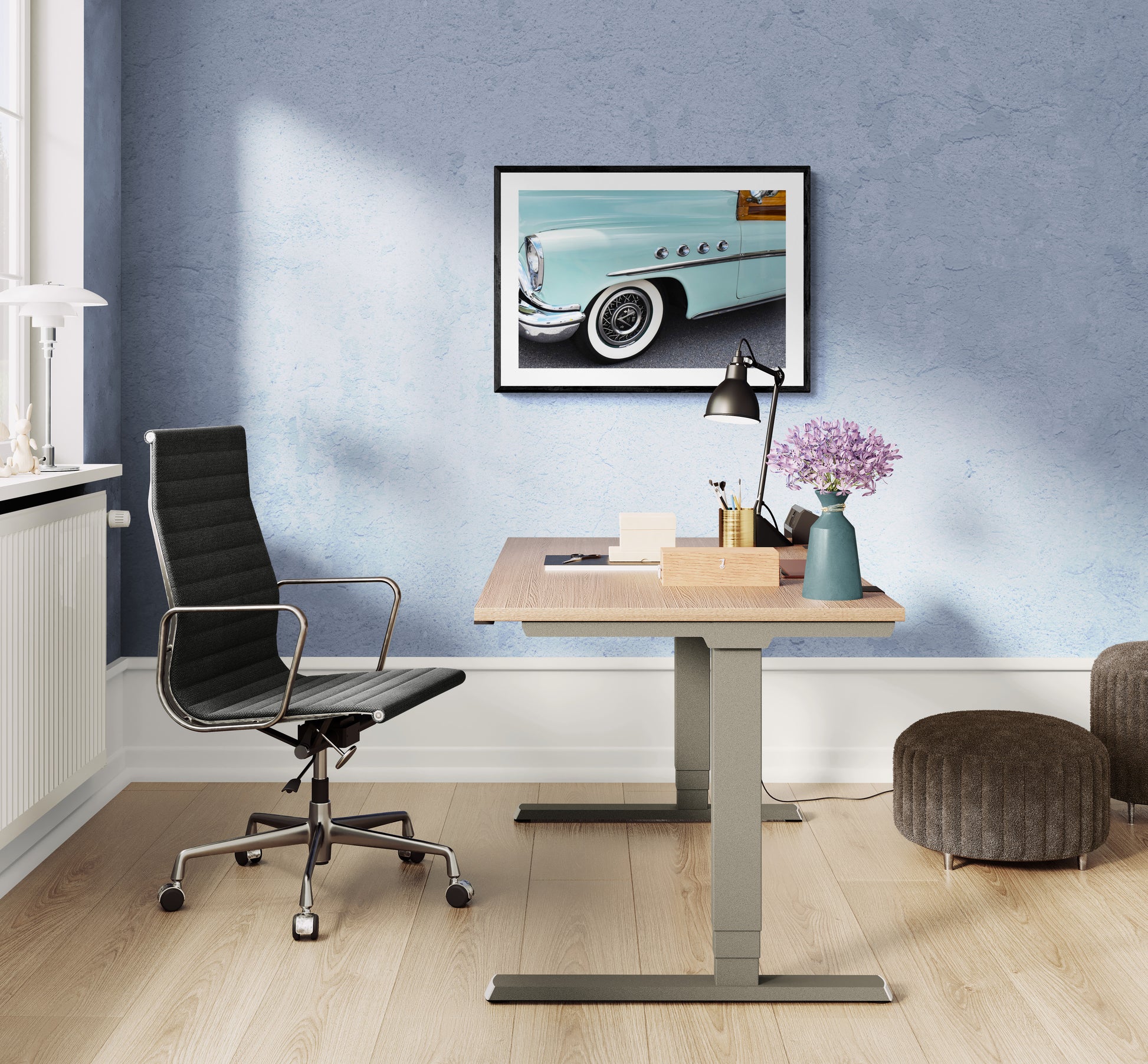 Modern office setup with a desk, chair, and framed picture  of a car on a blue wall.