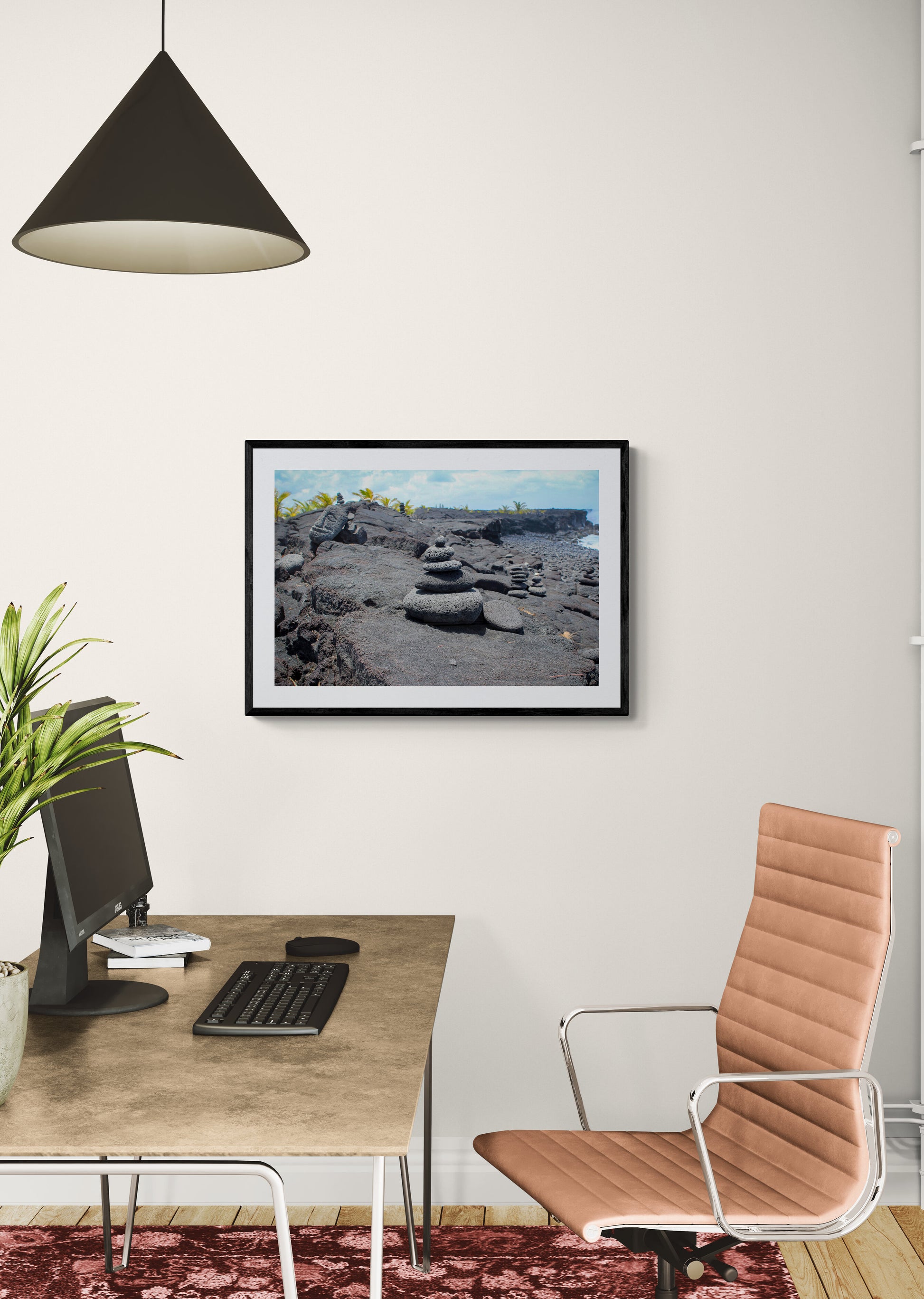 Framed photograph of a rocky landscape above a desk in a home office.