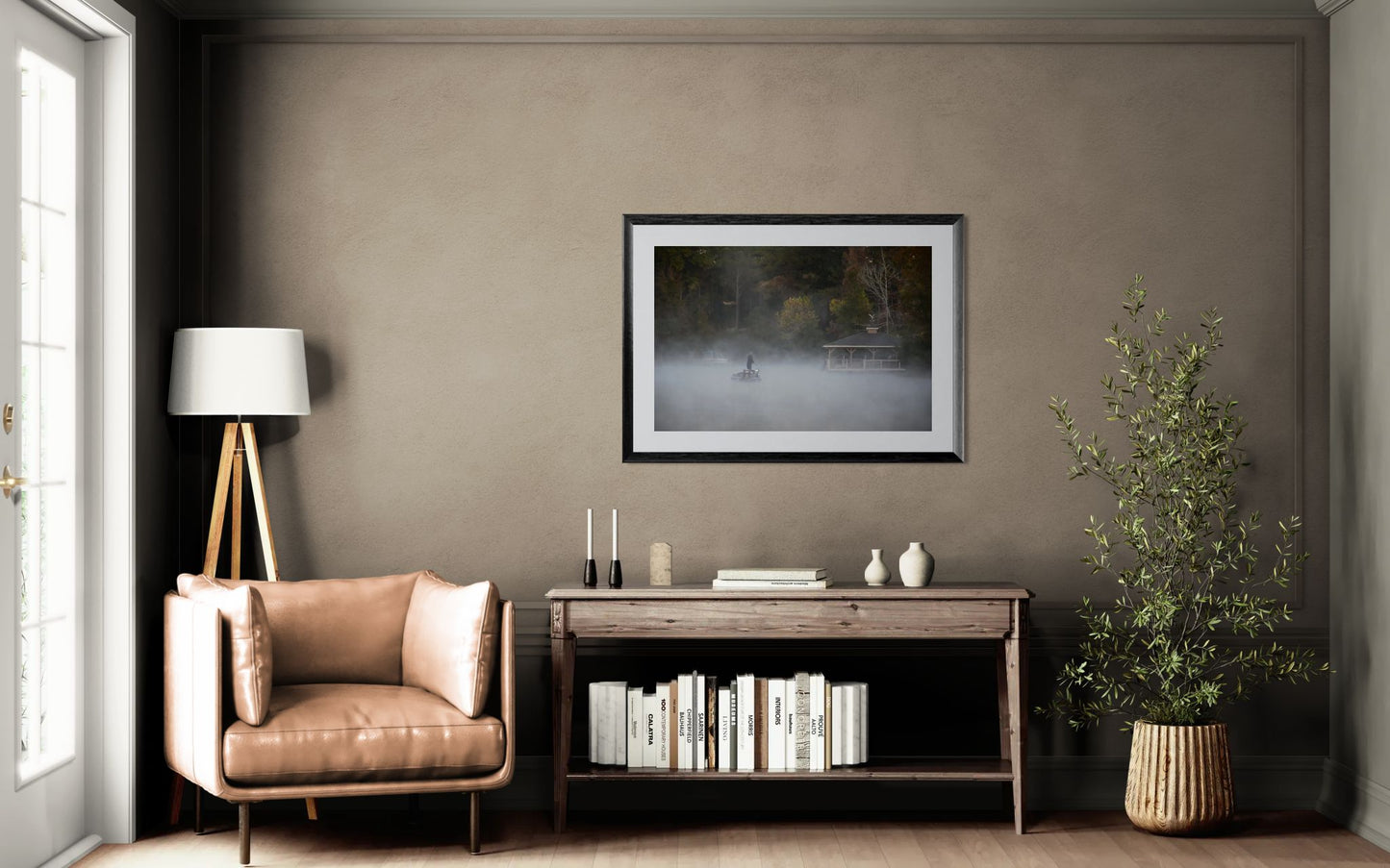 Person on a boat in a foggy lake with a gazebo in the background in a modern living room with a brown armchair, side table, and wall art.