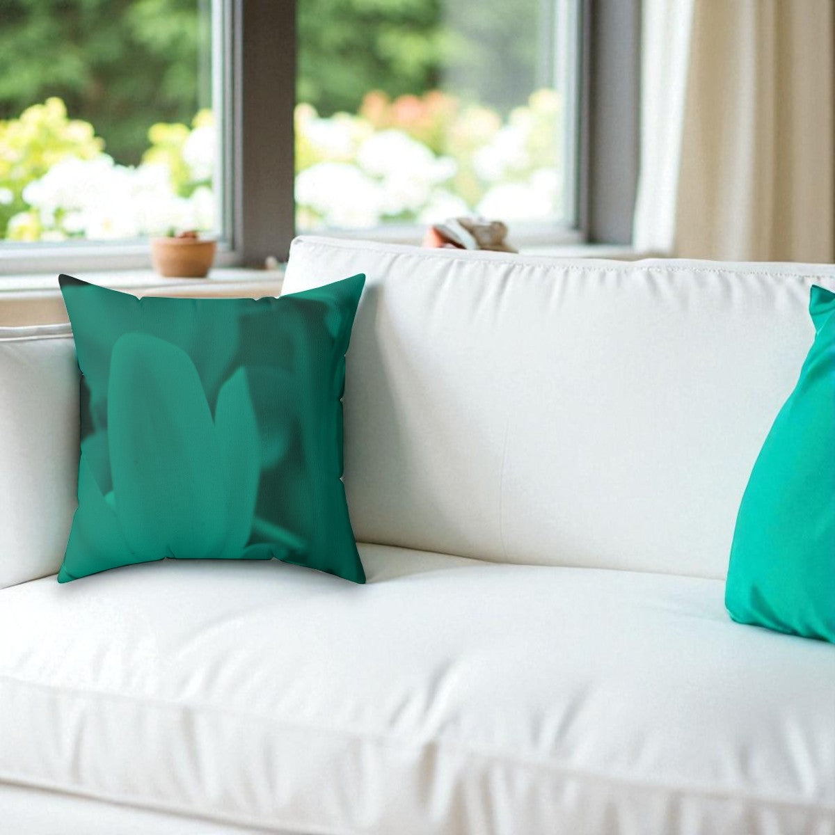 Teal pillows on a white sofa with a blurred outdoor background