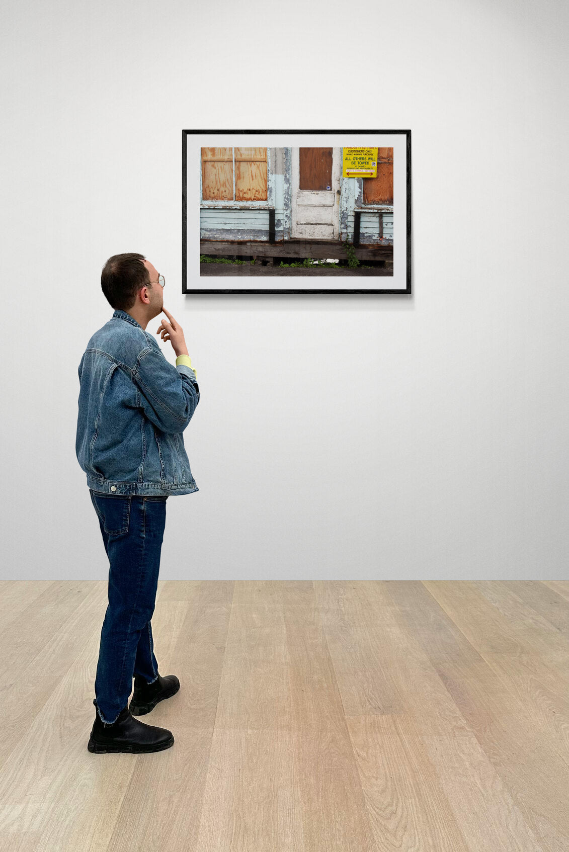 Man looking at a framed photograph in an art gallery. Weathered Lobster Store Original Photograph by Kim A. Bailey.