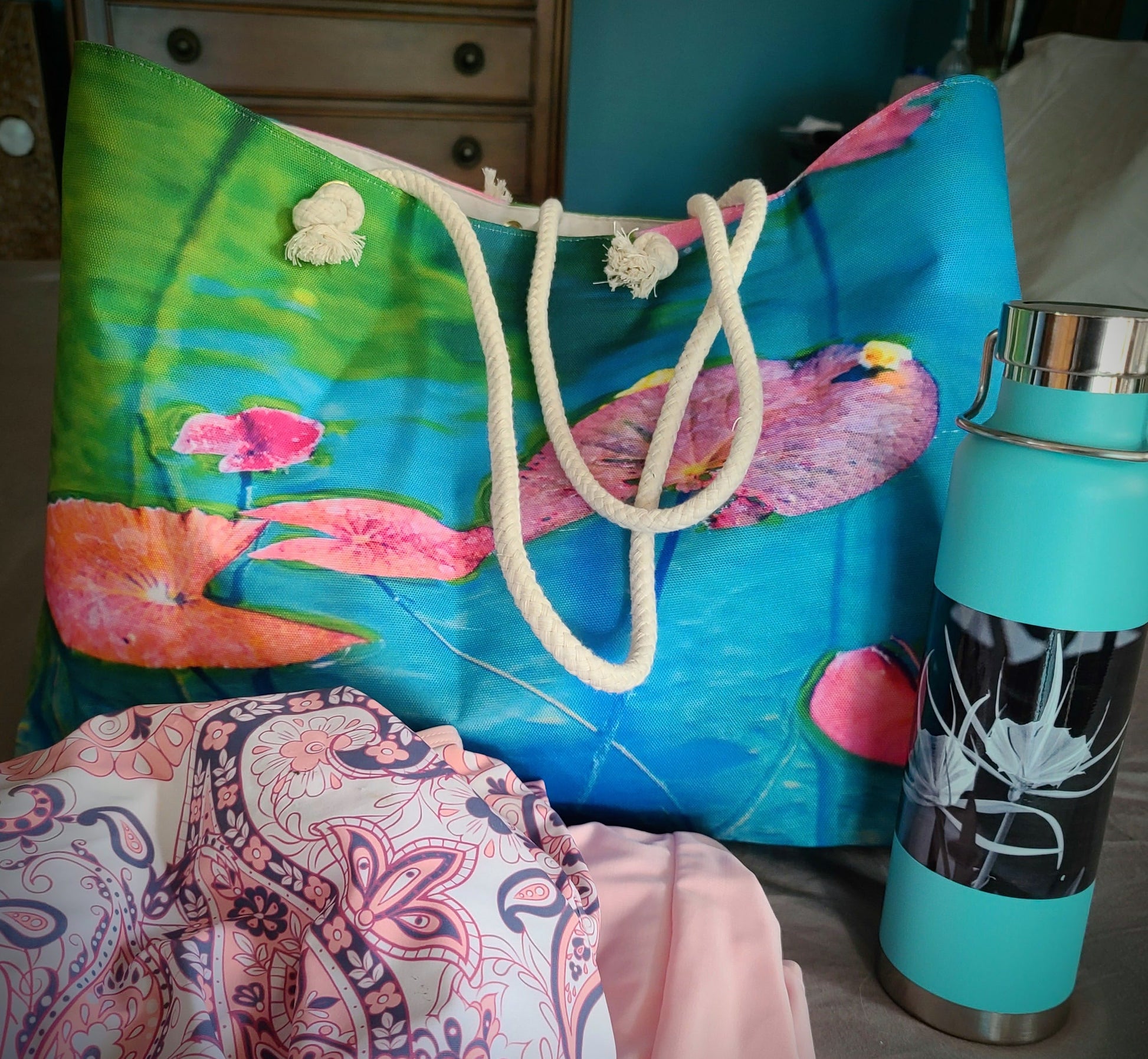 Colorful beach bag with Lily Pad design next to a turquoise water bottle.