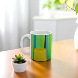 Colorful mug on a wooden table with a plant and vase in the background