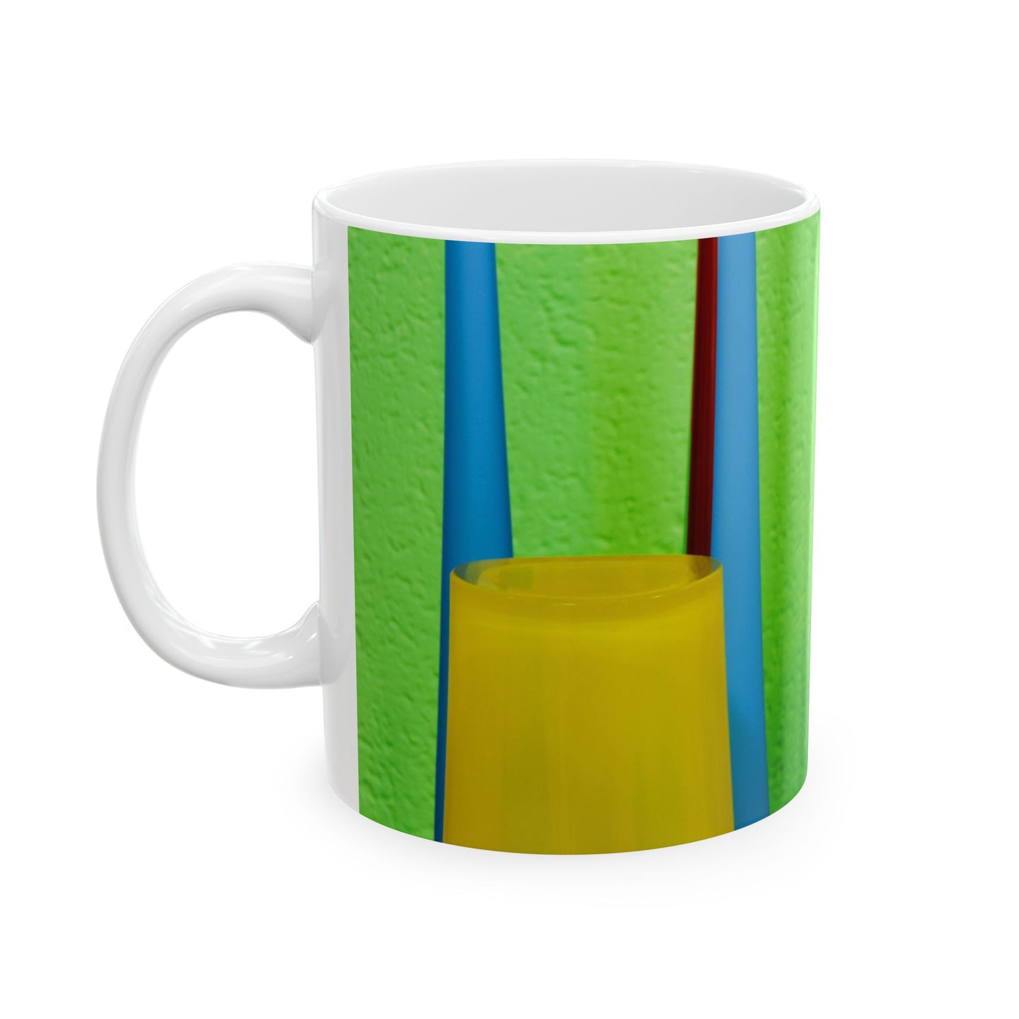 White mug with green, blue, and yellow design on a white background