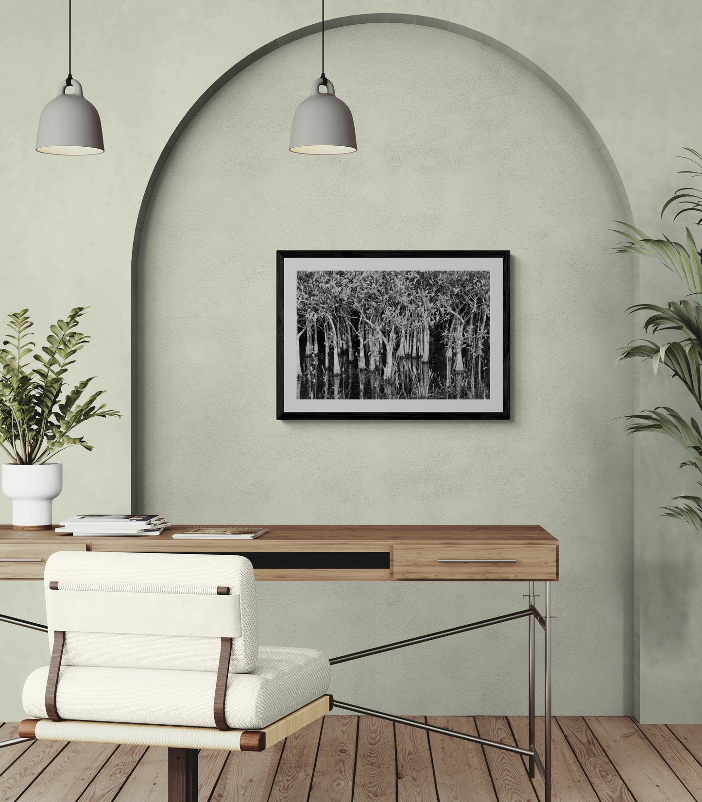 Modern office with a desk, chair, and framed artwork on a light green wall.